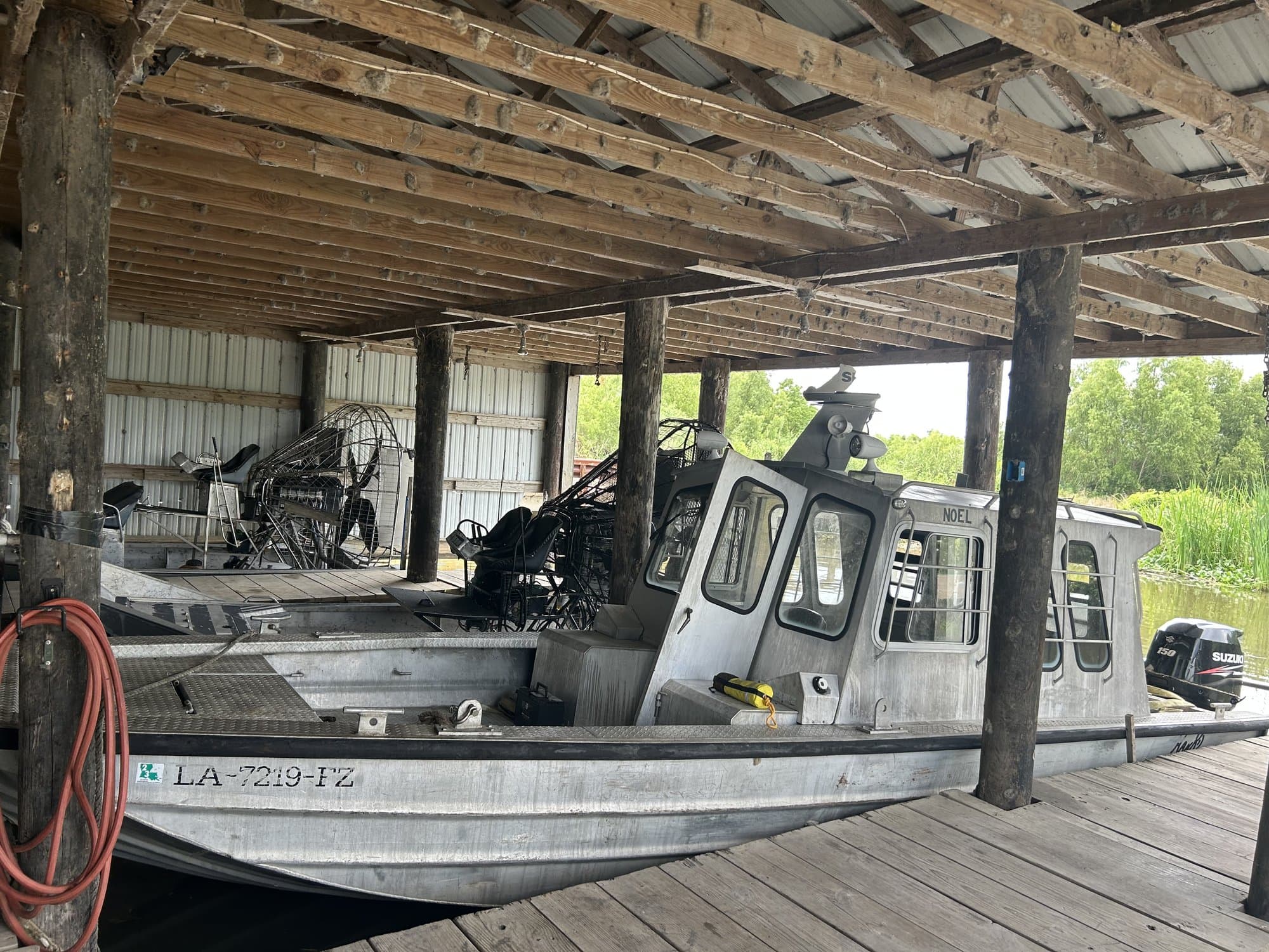 Airboat and aluminum crew boat staged in the boathouse at Larose